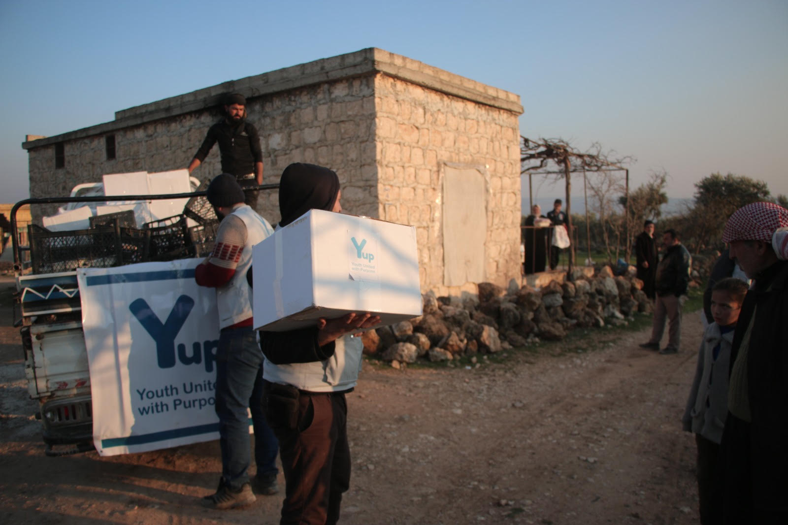YUP volunteers carrying aid boxes to families after the earthquake